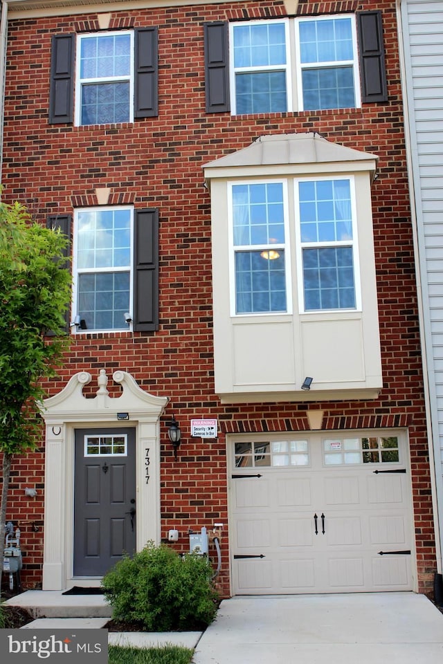 view of front of property with brick siding, an attached garage, and concrete driveway