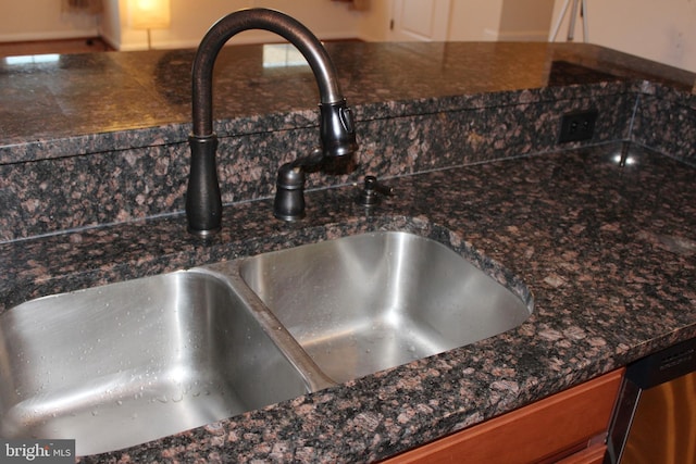 interior details with a sink and dark stone countertops