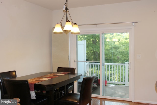 dining area featuring wood finished floors, baseboards, and a chandelier