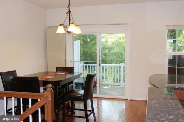 dining room featuring a notable chandelier, baseboards, and hardwood / wood-style flooring