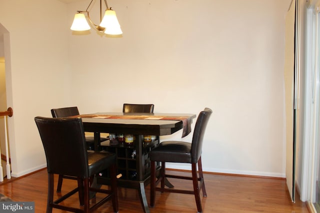 dining room with baseboards, an inviting chandelier, and wood finished floors