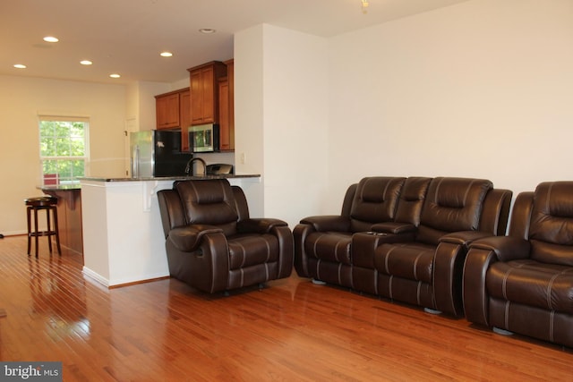 living room featuring recessed lighting, light wood-style floors, and baseboards