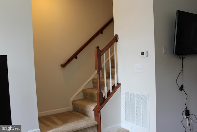 stairs featuring carpet flooring, baseboards, and visible vents