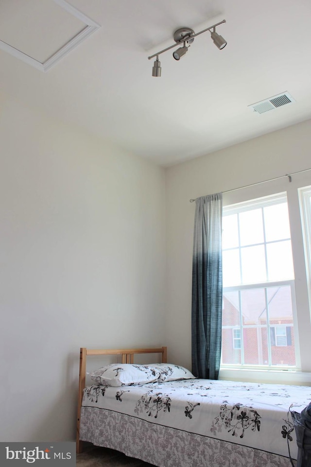 unfurnished bedroom featuring visible vents and track lighting