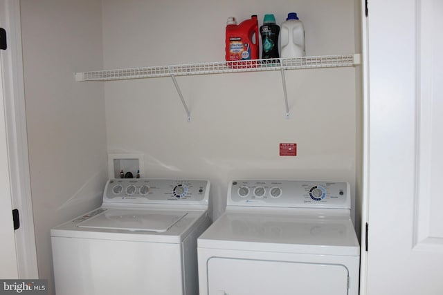 clothes washing area with washing machine and clothes dryer and laundry area