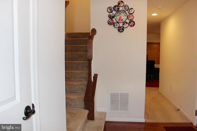 stairway featuring recessed lighting, visible vents, baseboards, and wood finished floors