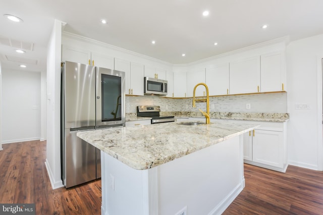 kitchen with a sink, dark wood finished floors, white cabinetry, stainless steel appliances, and decorative backsplash