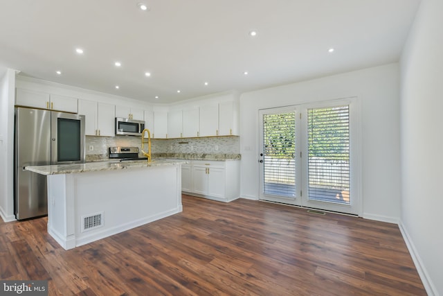 kitchen with visible vents, light stone countertops, decorative backsplash, appliances with stainless steel finishes, and white cabinetry