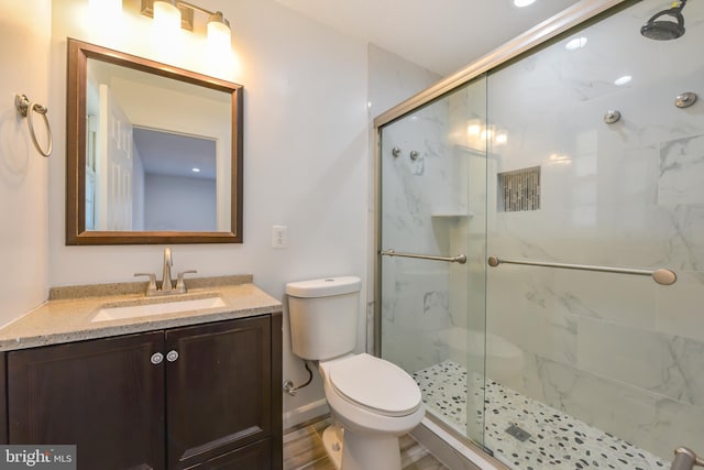 bathroom with vanity, toilet, and a stall shower