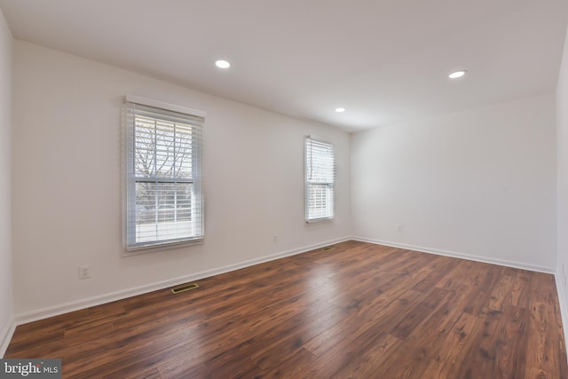 unfurnished room featuring dark wood finished floors, visible vents, recessed lighting, and baseboards