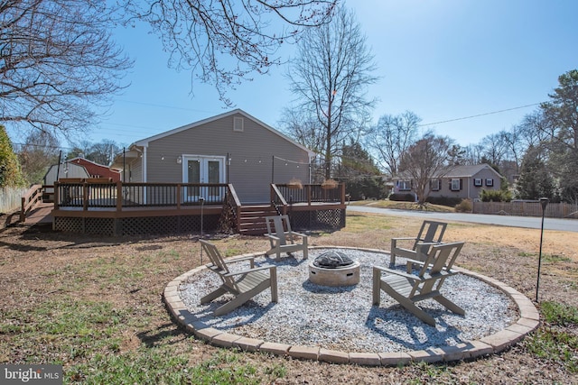 back of house with french doors, a fire pit, and a deck