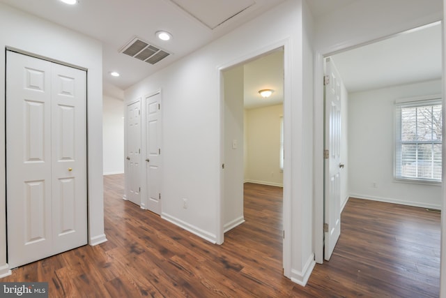 hall with visible vents, recessed lighting, dark wood-type flooring, and baseboards