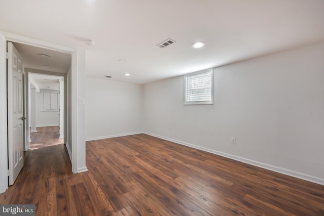 basement featuring dark wood-type flooring, recessed lighting, baseboards, and visible vents