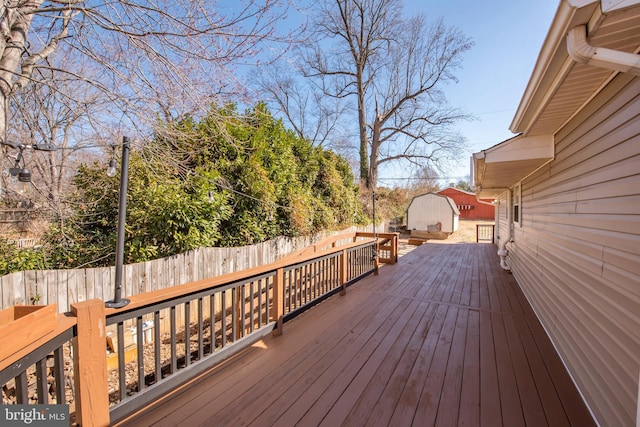 wooden terrace featuring an outbuilding and a fenced backyard