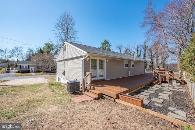 rear view of property featuring cooling unit, a wooden deck, and french doors