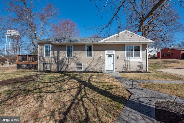 view of front of home with a deck and a front lawn