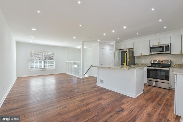 kitchen featuring backsplash, open floor plan, dark wood finished floors, recessed lighting, and appliances with stainless steel finishes