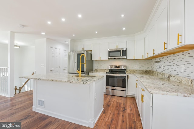 kitchen featuring a kitchen island with sink, stainless steel appliances, dark wood finished floors, and white cabinets