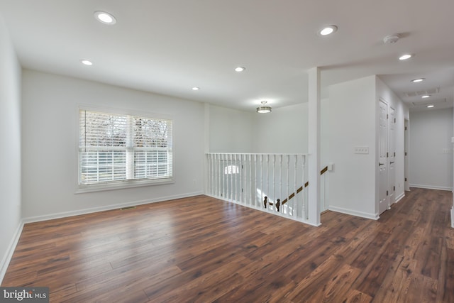 spare room with recessed lighting, baseboards, and wood finished floors