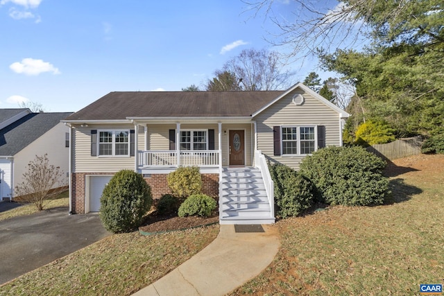 view of front of home featuring stairs, brick siding, covered porch, and driveway