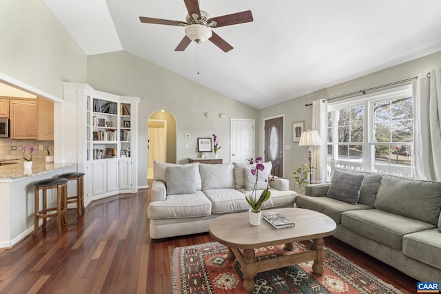 living area with arched walkways, dark wood-style floors, high vaulted ceiling, and ceiling fan