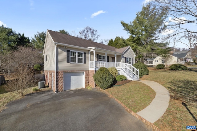 view of front of property featuring aphalt driveway, a porch, a front yard, brick siding, and central AC unit