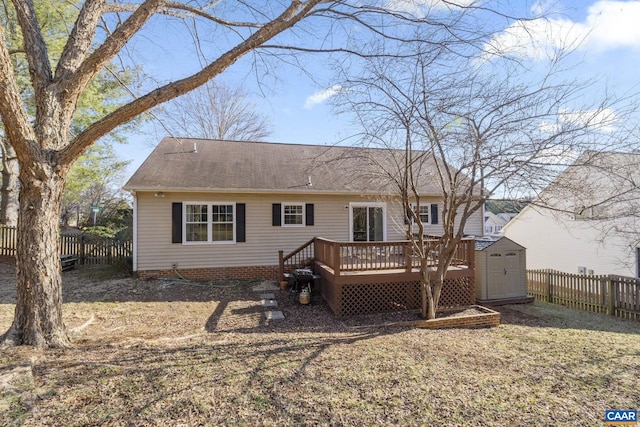 back of property featuring a deck, a fenced backyard, a storage shed, an outdoor structure, and a shingled roof