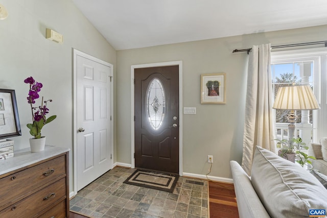 entrance foyer with visible vents, baseboards, lofted ceiling, and dark wood finished floors