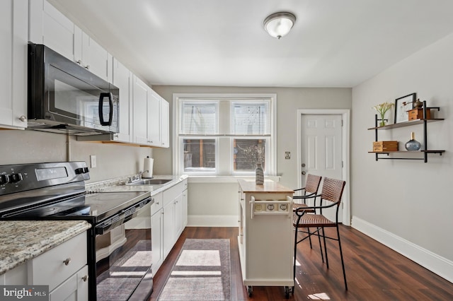 kitchen with a sink, dark wood-style floors, black appliances, and white cabinets