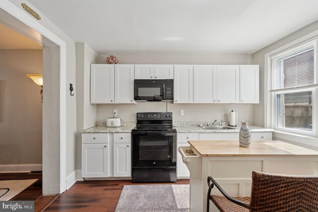 kitchen with dark wood-style floors, butcher block countertops, white cabinetry, and black appliances