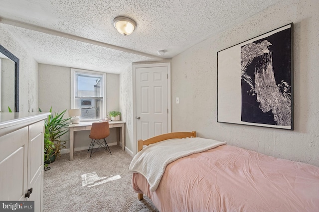 bedroom with carpet flooring, a textured ceiling, baseboards, and a textured wall