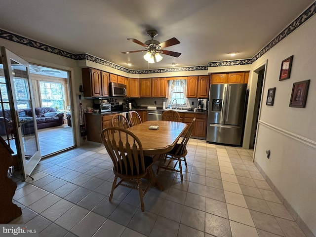 dining space with light tile patterned floors, baseboards, and a ceiling fan