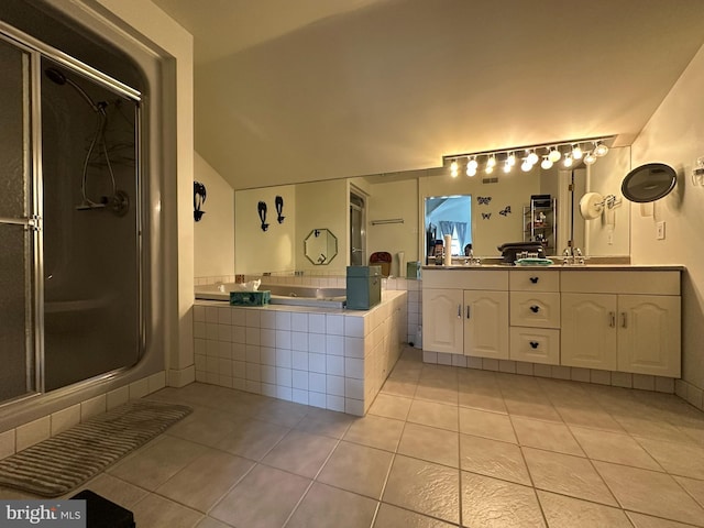 bathroom featuring tile patterned flooring, a garden tub, a shower stall, and a sink