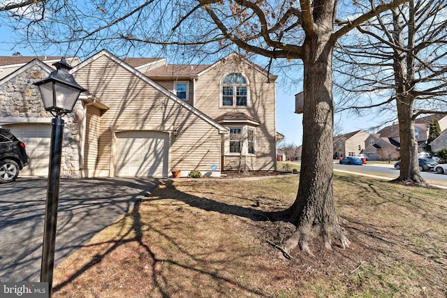 view of front facade with aphalt driveway, a residential view, and an attached garage