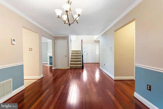 interior space with baseboards, visible vents, a fireplace with flush hearth, stairs, and hardwood / wood-style flooring