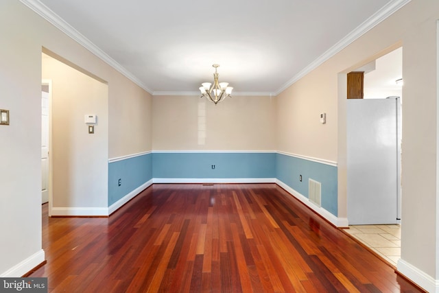 interior space with visible vents, baseboards, ornamental molding, hardwood / wood-style floors, and an inviting chandelier