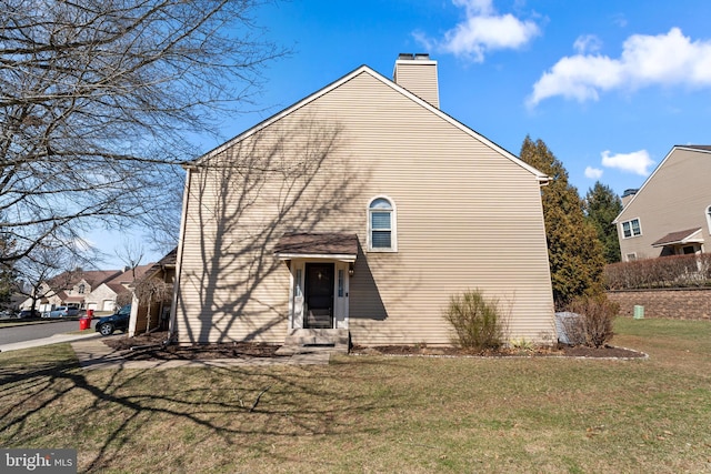 exterior space featuring a lawn and a chimney