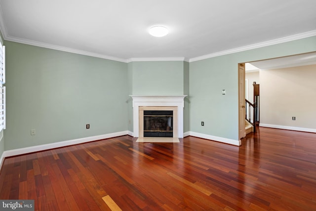 unfurnished living room featuring baseboards, a fireplace with flush hearth, hardwood / wood-style floors, and crown molding