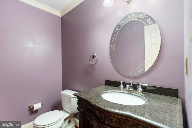 half bath with vanity, toilet, and ornamental molding