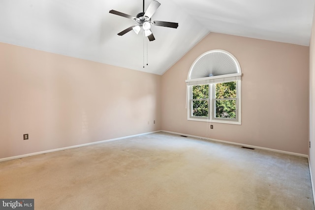 carpeted spare room featuring visible vents, baseboards, lofted ceiling, and a ceiling fan