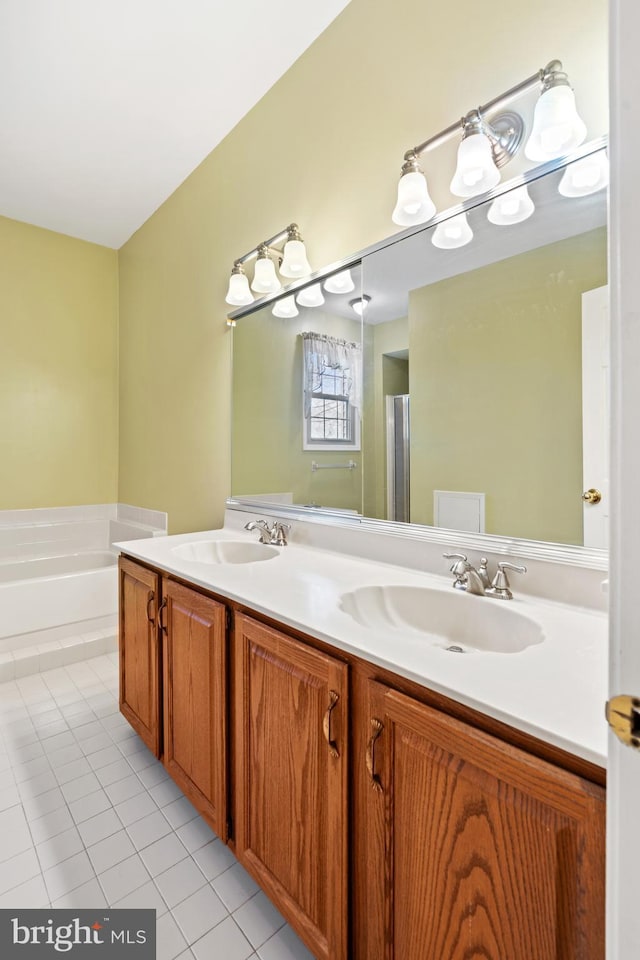 bathroom featuring a sink, a garden tub, double vanity, and tile patterned floors