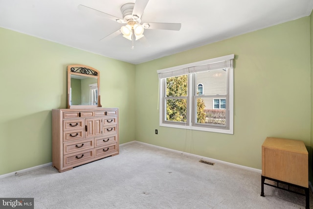 carpeted bedroom with visible vents, a ceiling fan, and baseboards