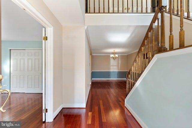 corridor with stairs, baseboards, wood-type flooring, and a chandelier