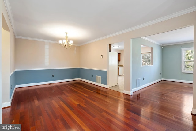 unfurnished room featuring baseboards, visible vents, ornamental molding, wood-type flooring, and a chandelier