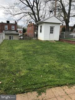 view of yard with an outbuilding, a fenced backyard, and a shed