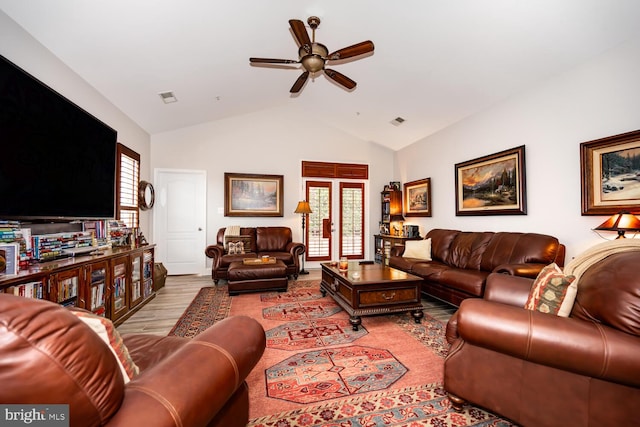 living room featuring visible vents, lofted ceiling, a ceiling fan, and wood finished floors