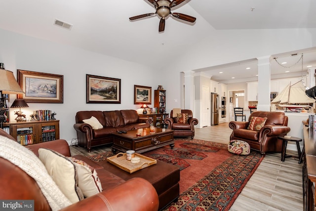 living room featuring light wood-style flooring, visible vents, ornate columns, and ceiling fan