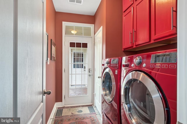 laundry room featuring washer and dryer, visible vents, cabinet space, and baseboards