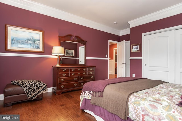 bedroom with crown molding, wood finished floors, a closet, and baseboards