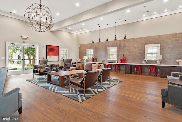 interior space with a wealth of natural light, a chandelier, light wood-style flooring, and a towering ceiling